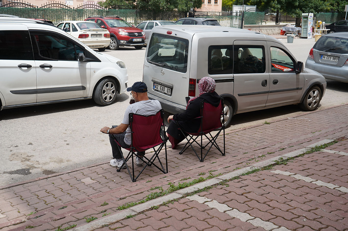 Sınav salonunda öğrenciler, kapıda dualarla bekleyen aileler